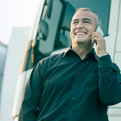 man listening to the phone besides a truck