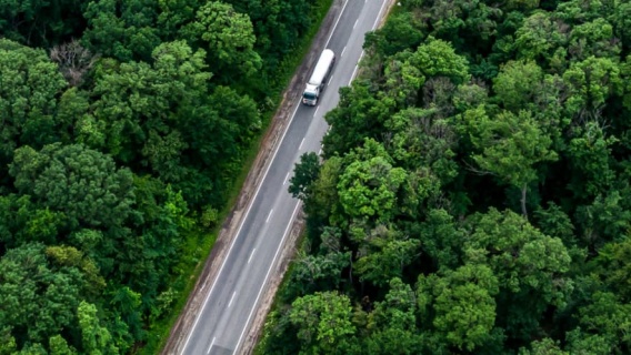 overhead view of Neste biofuel tanker driving through densely wooded area